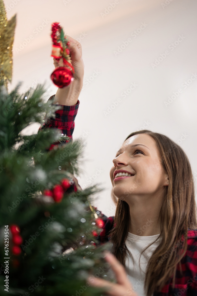 Cheerful woman decorate the christmas tree. Christmas atmosphere at cozy home interior