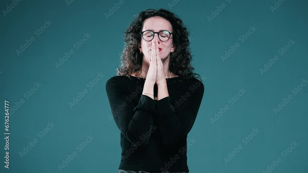 Woman closing her eyes holding her breath while Praying to God for help during difficult times, person seeking help and divine intervention Woman closing her eyes holding her breath while Praying to God for help during difficult times, person seeking help and divine intervention