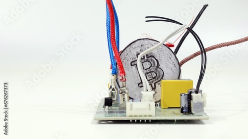 Criptovaluta Bitcoin isolata su sfondo bianco, all'interno di componenti elettronici. photo
