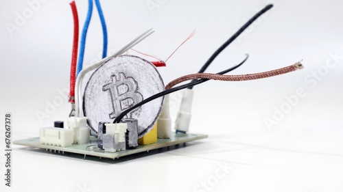 Criptovaluta Bitcoin isolata su sfondo bianco, all'interno di componenti elettronici. photo