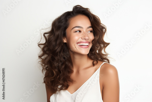 The portrait of a beautiful woman model with curly dark brown hair on a white background  shot in a studio. Generative AI.
