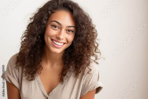 The portrait of a beautiful woman model with curly dark brown hair on a white background, shot in a studio. Generative AI.