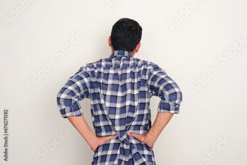 Back view of a man suffering low back pain