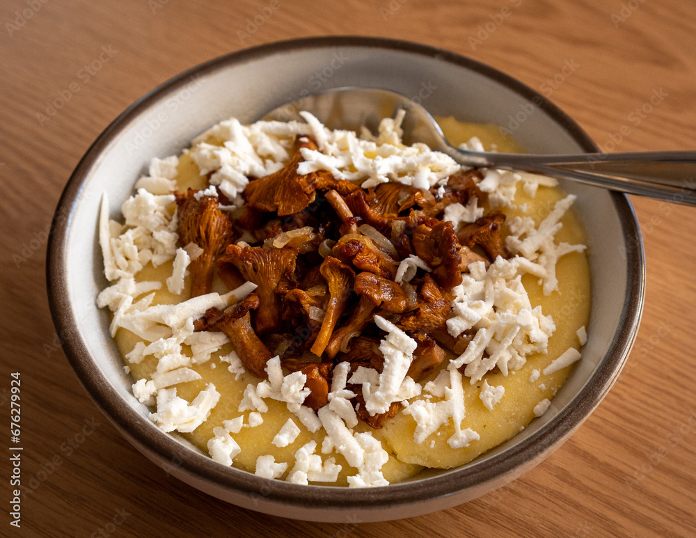 Tasty banosh served with brynza and mushrooms in bowl on table, top view. Traditional Ukrainian dish Tasty banosh served with brynza and mushrooms in bowl on table, top view. Traditional Ukrainian dish