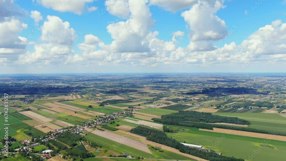 Bird's eye view of agricultural area and green wavy fields in sunny day. Agronomic industry. Agrarian region Europe. Cinematic aerial shot. Beauty of earth. Filmed in UHD 4k, drone video. Bird's eye view of agricultural area and green wavy fields in sunny day. Agronomic industry. Agrarian region Europe. Cinematic aerial shot. Beauty of earth. Filmed in UHD 4k, drone video.
