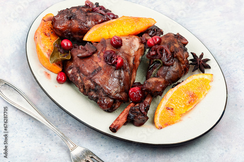 Baked chicken legs with orange and berries.
