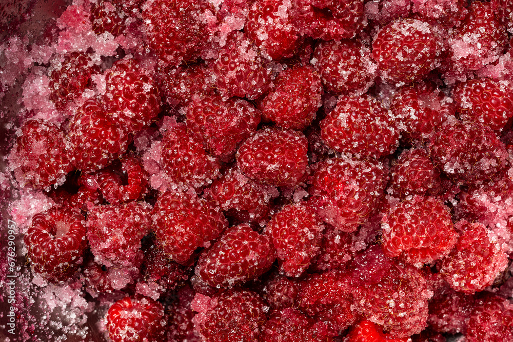 Fresh red raspberry berry, covered with granulated sugar for jam