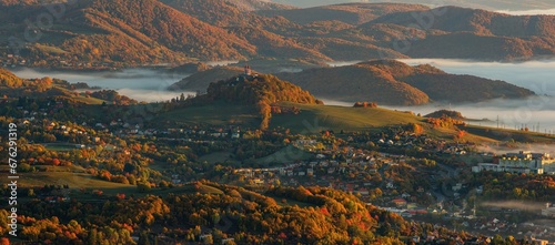 Beautiful autumn landscape of a church on a hill,  autumn fog in the valleys. Idyllic scenery from a bird's eye view of the picturesque town of Banska Stiavnica photo