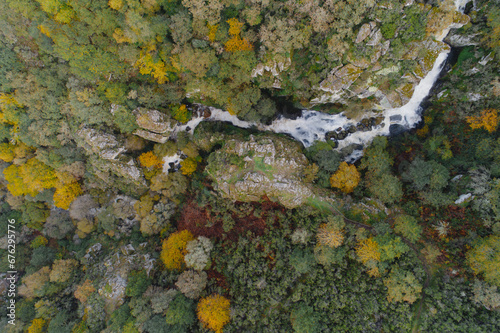 zenithal aerial drone view of a waterfall in a mountain forest