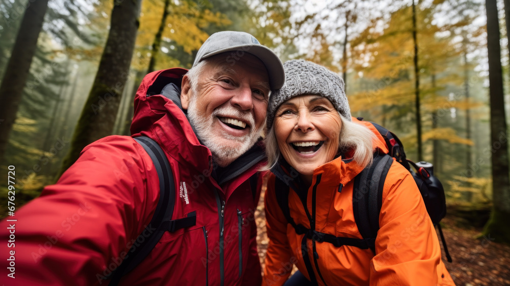 POV portrait of active senior couple looking at camera and smiling while taking selfie photo during hike in autumn forest, copy space POV portrait of active senior couple looking at camera and smiling while taking selfie photo during hike in autumn forest, copy space