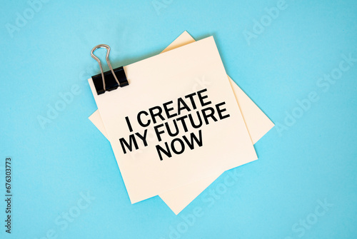 Text I CREATE MY FUTURE NOW on sticky notes with copy space and paper clip isolated on red background. Finance and economics concept.