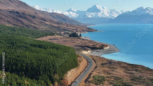 Road trip to Mount Cook village. Cars on scenic road, lakeshore of Lake Pukaki. Aerial birds eye