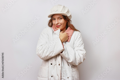 Cuadro en lienzo A beautiful girl is dressed in a white autumn raincoat and a white warm hat