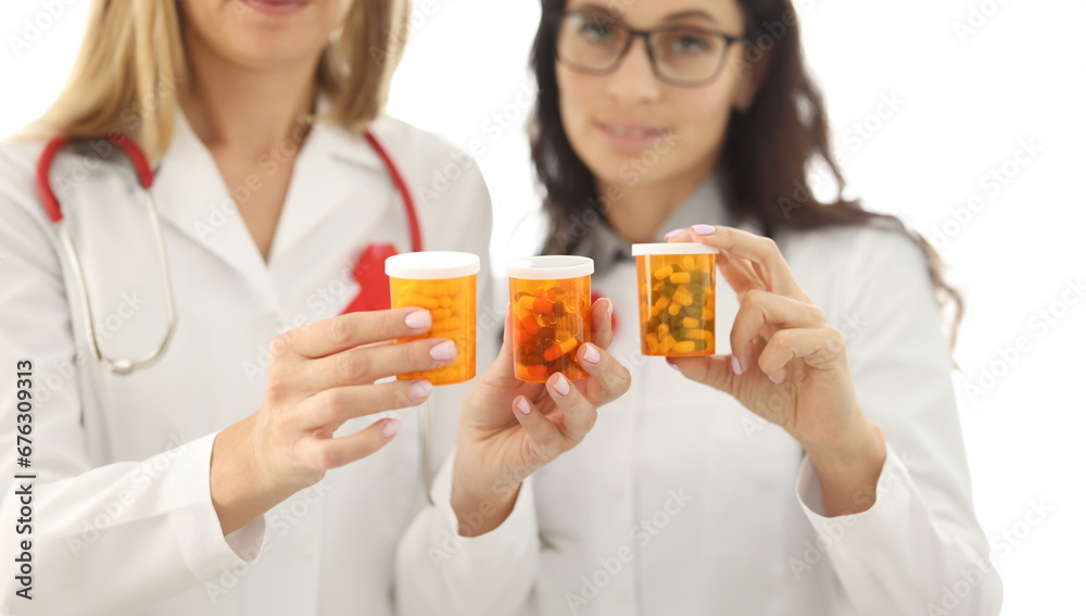 Woman doctor holding jars of medicines closeup. HIV treatment concept Woman doctor holding jars of medicines closeup. HIV treatment concept