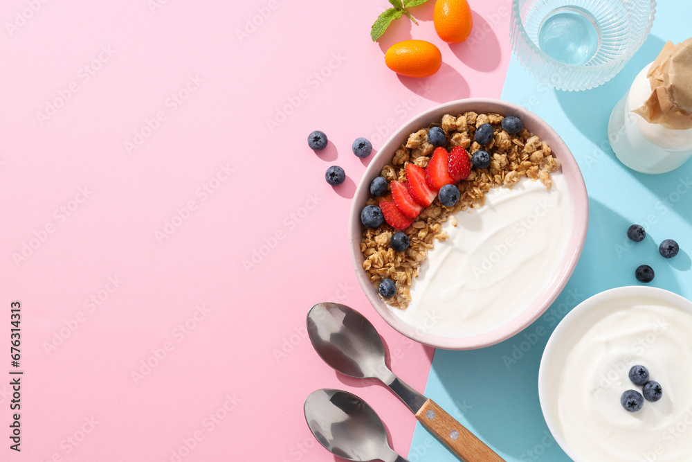 Yogurt with fruits in a bowl on a pink and blue background Yogurt with fruits in a bowl on a pink and blue background