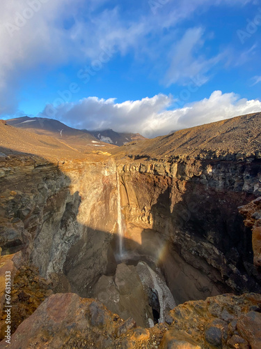 View from a helicopter to a high waterfall on a sunny day