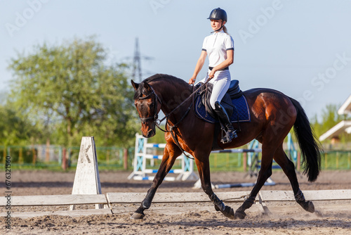 Young rider woman riding horse warming up before showjumping competition © skumer