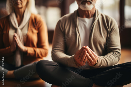 active elderly man and woman doing yoga together indoors to improve their physical condition
