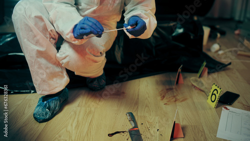 A forensic expert is collecting a blood sample from a marked area with bloodied evidence © Synthex🇺🇦