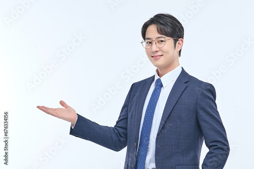 A young and handsome Asian man in a suit is wearing glasses and making various facial expressions and hand gestures.