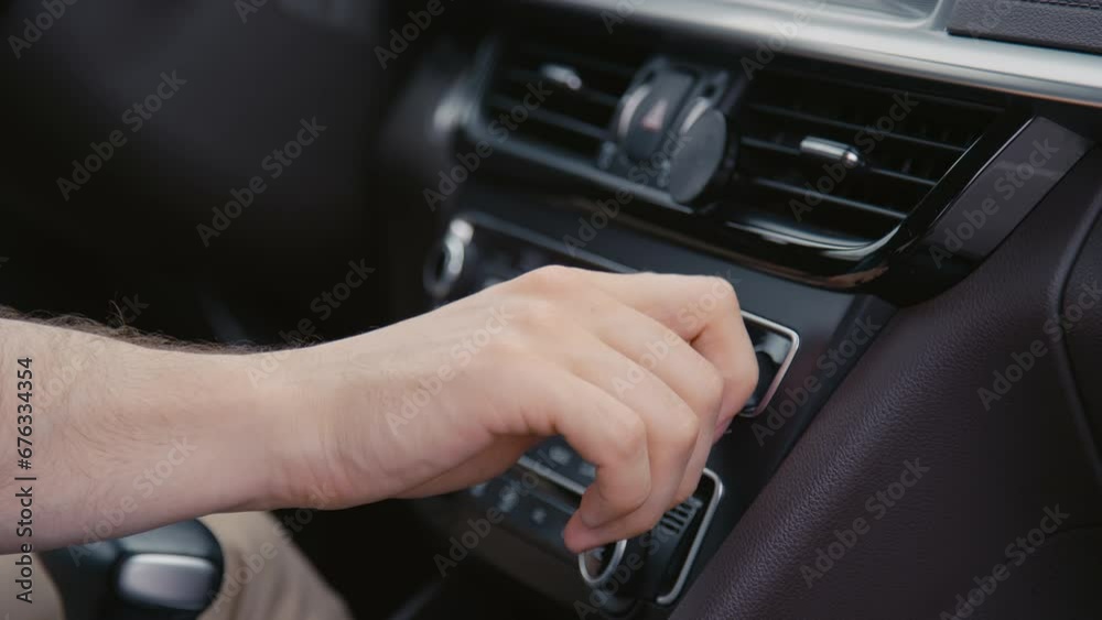 Closeup side shot of unrecognizable drivers hand adjusting car stereo functions while driving Closeup side shot of unrecognizable drivers hand adjusting car stereo functions while driving