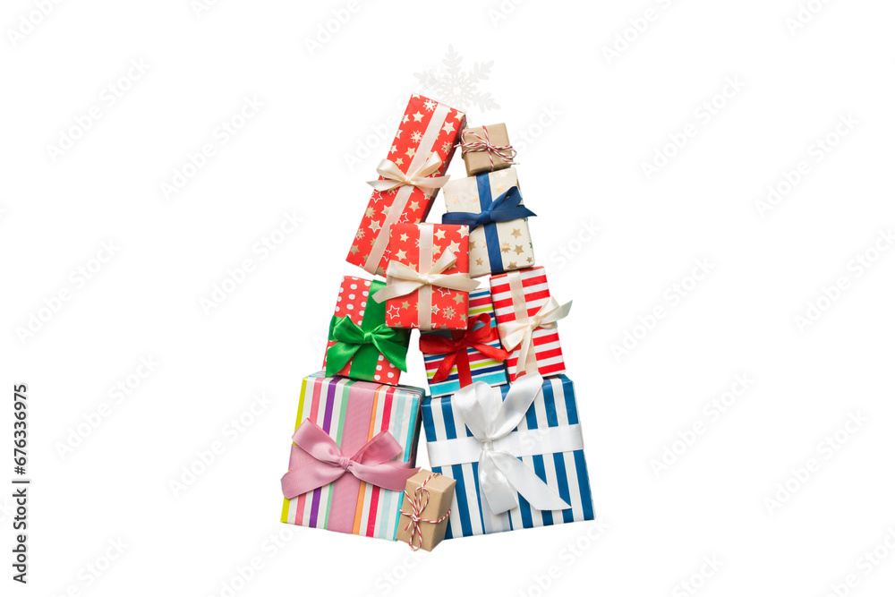 Obraz premium Isolated Christmas tree made of beautifuly wrapped presents on colored background, view from above. New Year gift box minimal concept
