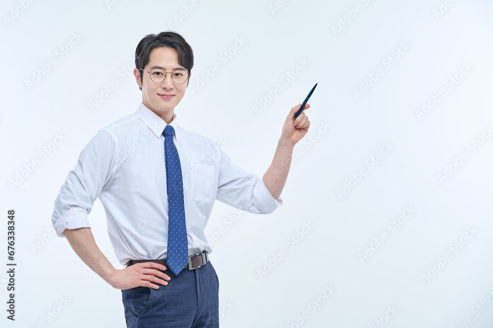 A young, handsome Asian man wearing glasses and a dress shirt and tie is holding a pen and explaining about business. A young, handsome Asian man wearing glasses and a dress shirt and tie is holding a pen and explaining about business.