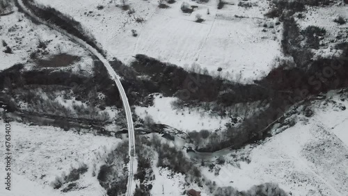 Footage of a snow covered countryside in mountion from above photo