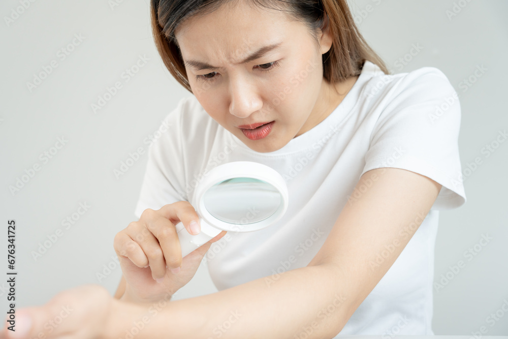 skin problem and beauty. asian woman use magnifying glass look itchy skin from skin allergic, shocked, steroid allergy, sensitive, chemical allergy, rash, insect bites, Seborrheic Dermatitis. skin problem and beauty. asian woman use magnifying glass look itchy skin from skin allergic, shocked, steroid allergy, sensitive, chemical allergy, rash, insect bites, Seborrheic Dermatitis.