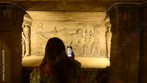 Girl record hieroglyphs inside Catacombs of Kom El Shoqafa, Alexandria, Egypt photo