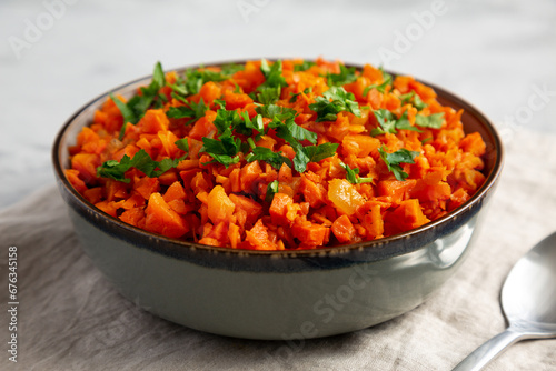 Homemade Smoky Spiced Carrot Rice with Parsley in a Bowl, side view.