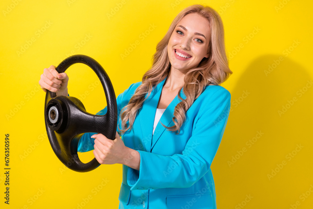 Profile portrait of gorgeous positive lady beaming smile arms hold steering wheel isolated on yellow color background Profile portrait of gorgeous positive lady beaming smile arms hold steering wheel isolated on yellow color background