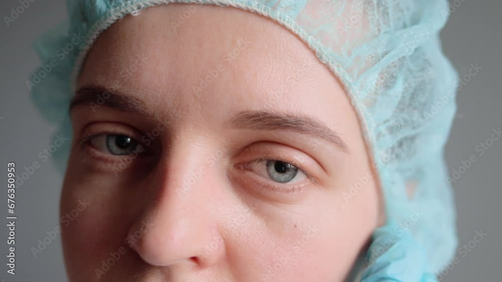 Medic surgeon. Clinic medicine. Tired exhausted young female doctor or nurse wearing uniform medical cap taking off face mask after finishing surgical procedures looking at camera. Medic surgeon. Clinic medicine. Tired exhausted young female doctor or nurse wearing uniform medical cap taking off face mask after finishing surgical procedures looking at camera.