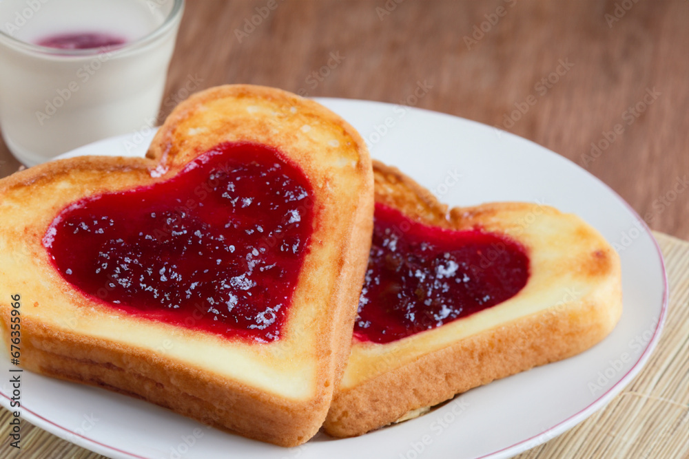 heart shaped cookies. shortbread lies on a white plate near a mug with compote, evening tea party heart shaped cookies. shortbread lies on a white plate near a mug with compote, evening tea party