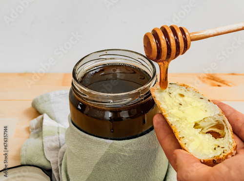 Kromka chleba z masłem polewana plynnm świeżym miodem pszczelim