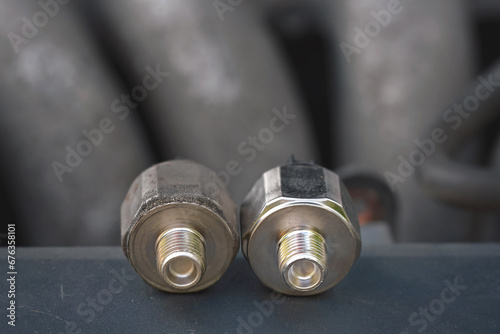 Replacing broken engine knock sensor, engine detonation. Knock sensor. Bad knock sensor and new one ready to replace. Faulty knock sensor, engine problems. Car maintenance. Selective focus