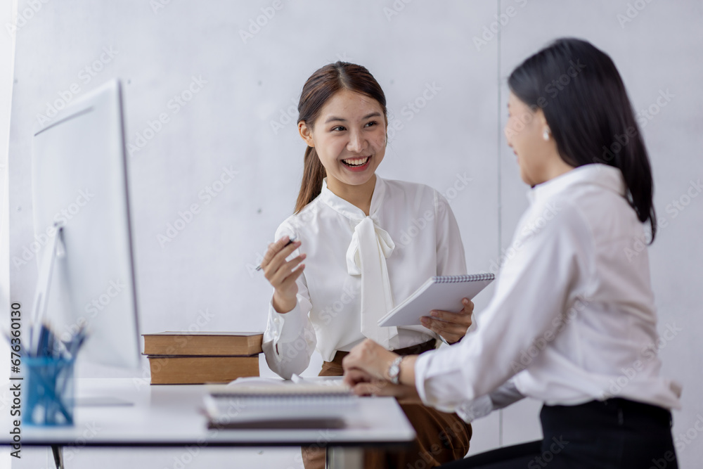 Two asian confident business women point to graphs and charts to analyze market data, balance sheet, account, net profit to plan new sales strategies to increase production capacity. Two asian confident business women point to graphs and charts to analyze market data, balance sheet, account, net profit to plan new sales strategies to increase production capacity.