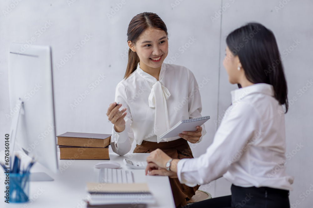 Two asian confident business women point to graphs and charts to analyze market data, balance sheet, account, net profit to plan new sales strategies to increase production capacity. Two asian confident business women point to graphs and charts to analyze market data, balance sheet, account, net profit to plan new sales strategies to increase production capacity.