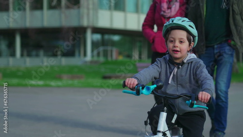 Child riding bicycle wearing protective helmet during autumn season. Happy small boy exercising outdoors being active