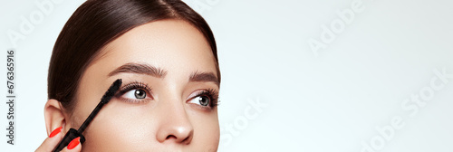 Beauty woman applying black mascara on eyelashes with makeup brush. Eyelash extensions. makeup, cosmetics. beauty, skincare photo