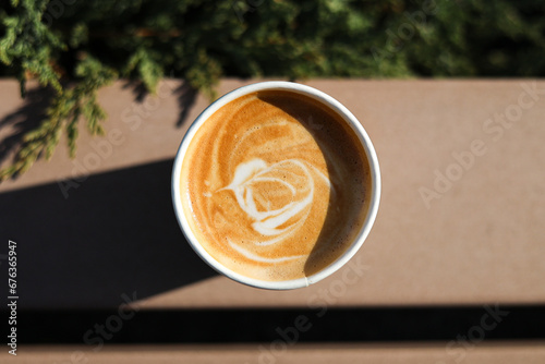 Obraz na płótnie Morning coffee. Close up photo of the milk froth foam made on top of a flat white coffee. Wooden bench background. Coffee to go. w salonie