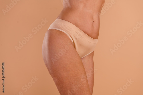Photo of slim adorable senior lady hips dressed lingerie enjoying spa procedures isolated beige color background