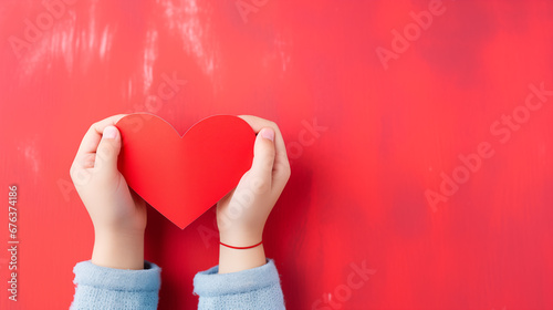 Hands holding blank paper greeting or invitation card over red background with heart shape. Christmas, Valentine day, New Year, winter holidays concept.