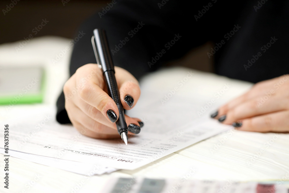 Accountant fill American tax form 1040 Individual income tax return in end of tax period. Taxation and paperwork routine in United States Accountant fill American tax form 1040 Individual income tax return in end of tax period. Taxation and paperwork routine in United States