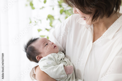 赤ちゃんを抱っこして見つめ合う母親　顔無し 高齢出産や不妊治療などのイメージ photo