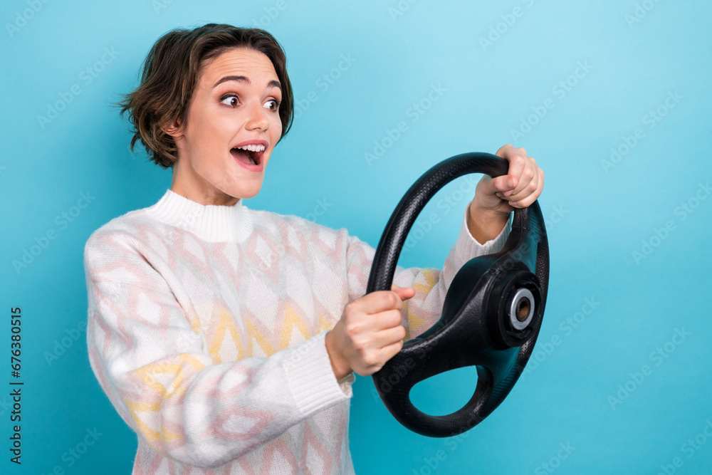 Photo portrait of lovely young lady excited hold steering wheel dressed stylish white garment isolated on blue color background Photo portrait of lovely young lady excited hold steering wheel dressed stylish white garment isolated on blue color background