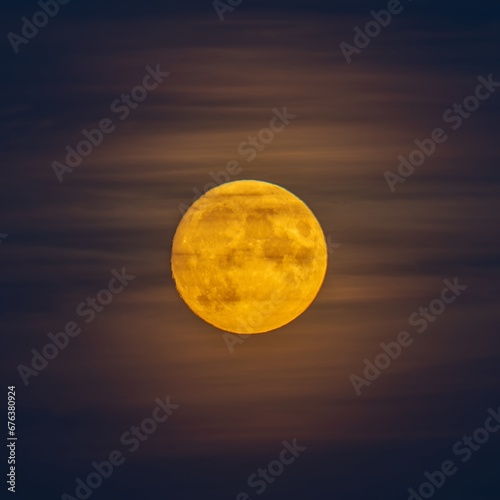 The big yellow moon shines in the sky