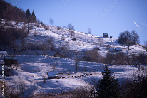 Ancient romanian old barn on a frosty day. Wooden construction at the base of the high mountains in the winter season