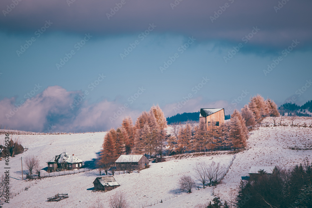 Ancient romanian houses on the frozen hills in the middle of winter. Wonderful landscape in the cold season with rustic buildings at the foot of the high mountains Ancient romanian houses on the frozen hills in the middle of winter. Wonderful landscape in the cold season with rustic buildings at the foot of the high mountains