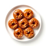 Top view of plate with caramel peanut donuts on white background.